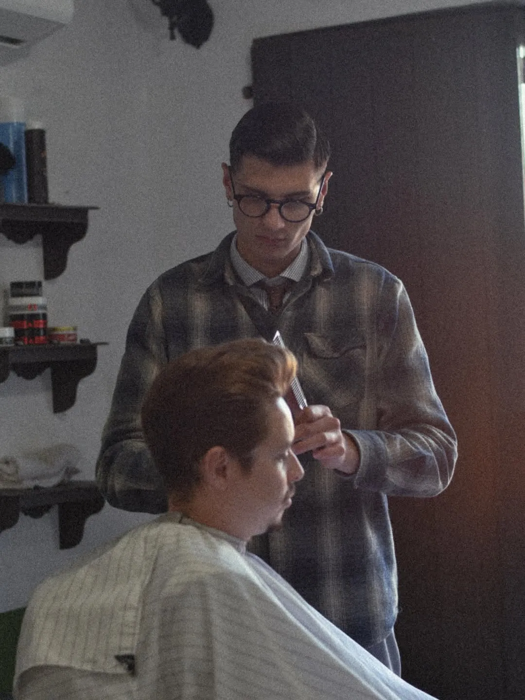 Barbeiro da Punchline finalizando o corte de um cliente na cadeira