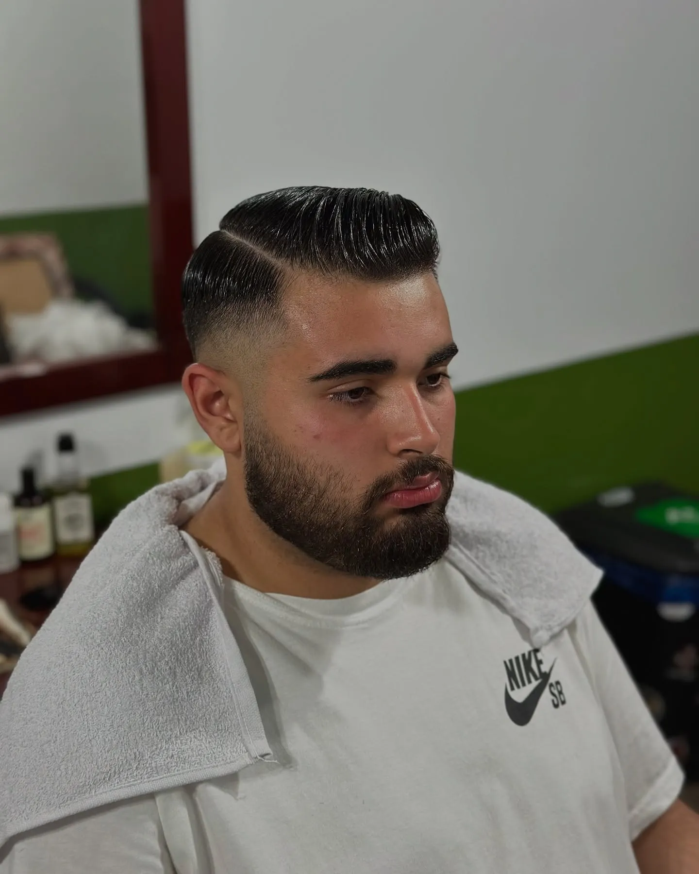 Corte social com risco lateral marcado e barba cheia alinhada